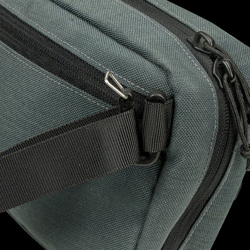 Close-up of the Condor Tech Pouch in dark green fabric, perfect for EDC or the range, featuring a black zipper, black strap, and silver hardware on one corner.